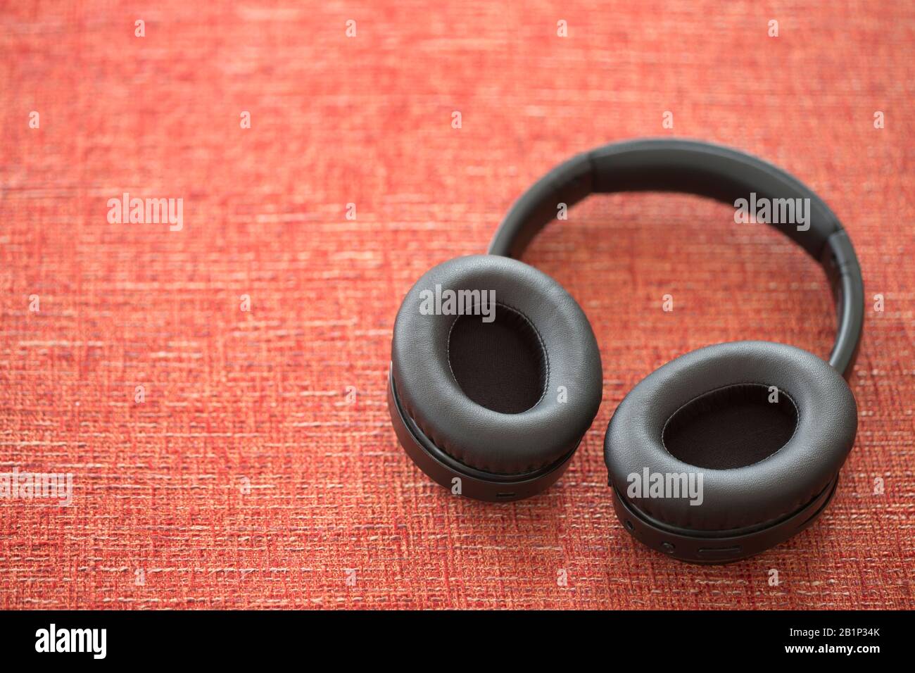 black wireless headphone on red background Stock Photo