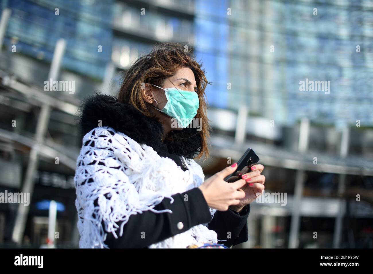 Milan, Italy. 26th Feb, 2020. A woman wears a face mask in Milan, Italy, Feb. 26, 2020. A total of 400 people have tested positive for the novel coronavirus in Italy till Wednesday evening. The government has placed 11 towns, 10 in Lombardy and one in Veneto, under lockdown in an effort to contain the epidemic. Credit: Daniele Mascolo/Xinhua/Alamy Live News Stock Photo