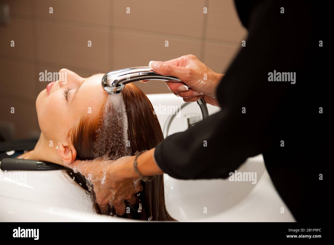 Hair stylist at work hairdresser washing hair to the customer before
