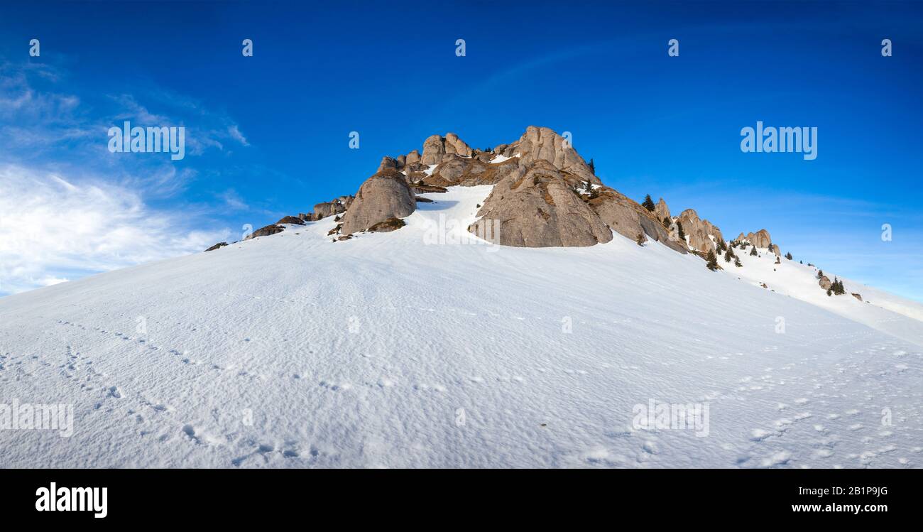 Panoramic view of Mount Ciucas peak covered in snow at sunset on winter, part of Romanian Carpathian Range Stock Photo