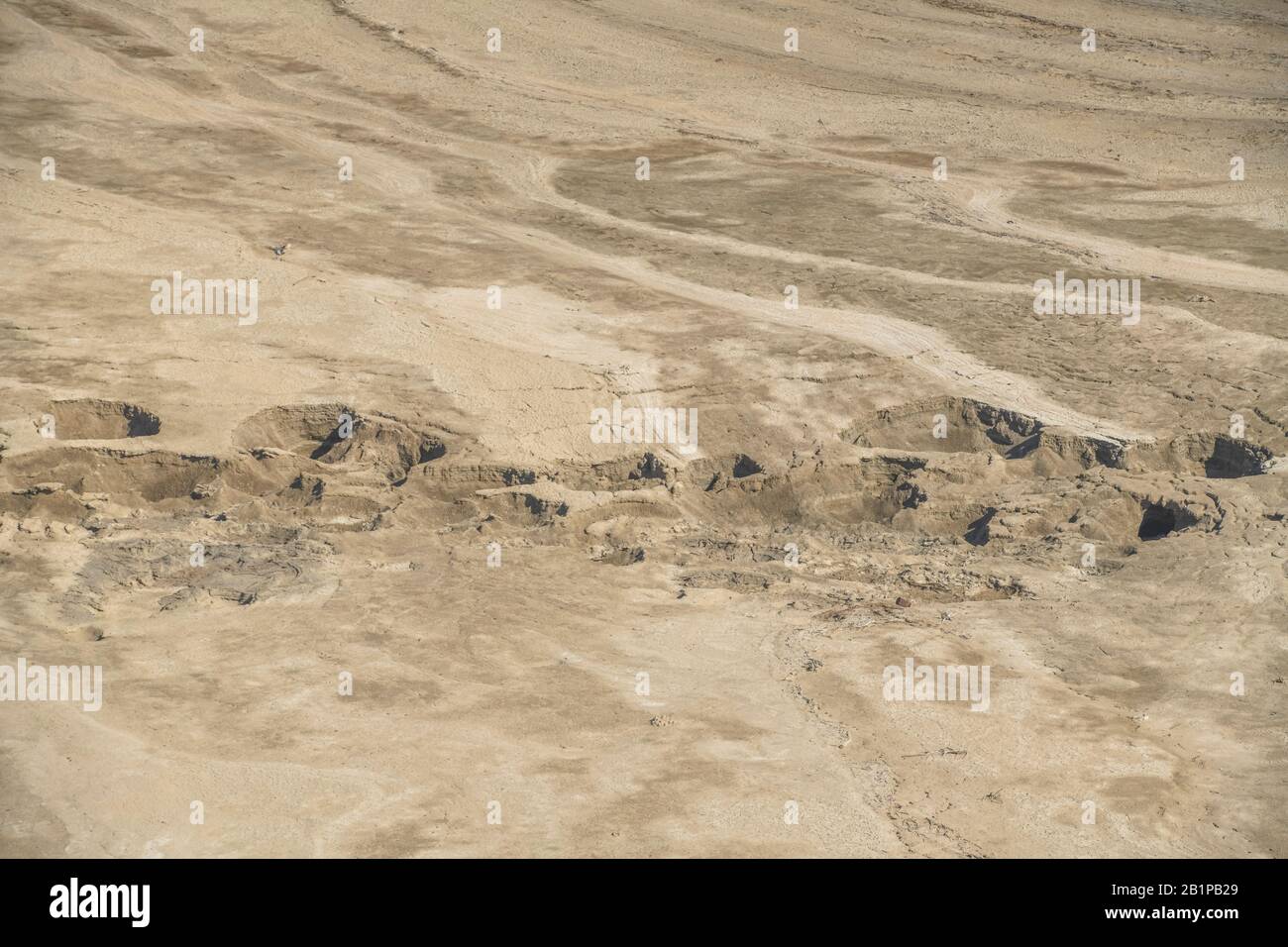 Ausgetrocknete Wüstenformation mit Schlucklöchern am Toten Meer, Israel Stock Photo