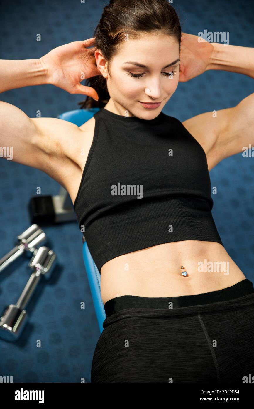 Attractive fit woamn working out abs in fitness gym, making ab intervals Stock Photo