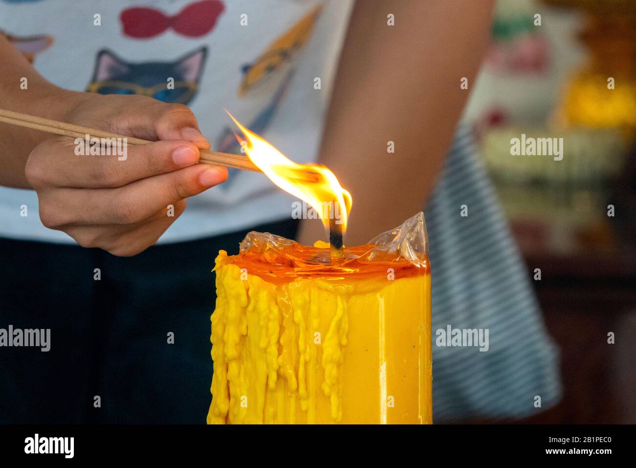 Woman lighting a candle in Lak Mueang, Bangkok, Thailand Stock Photo