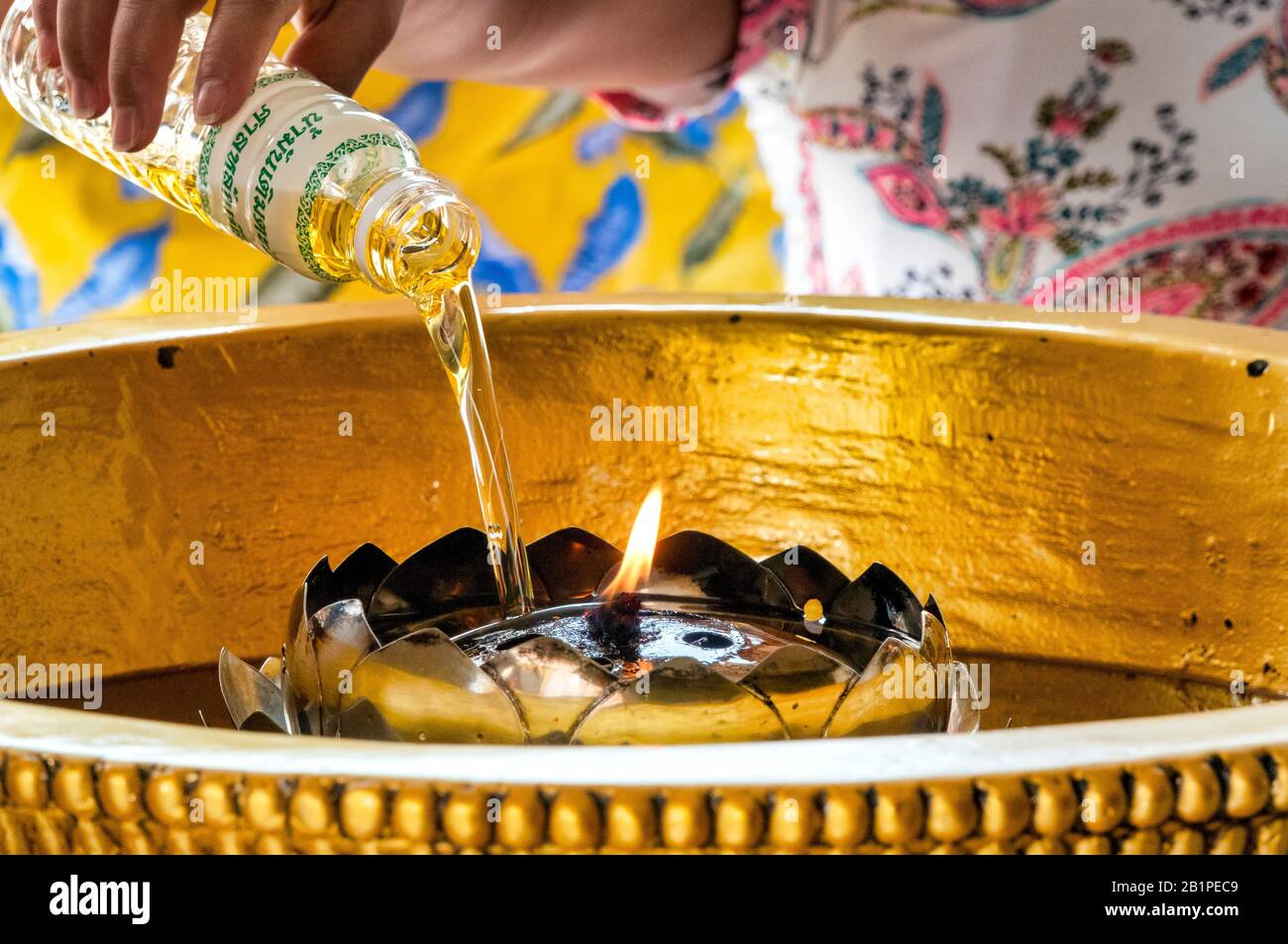 Woman lighting an oil candle in Lak Mueang, Bangkok, Thailand Stock Photo