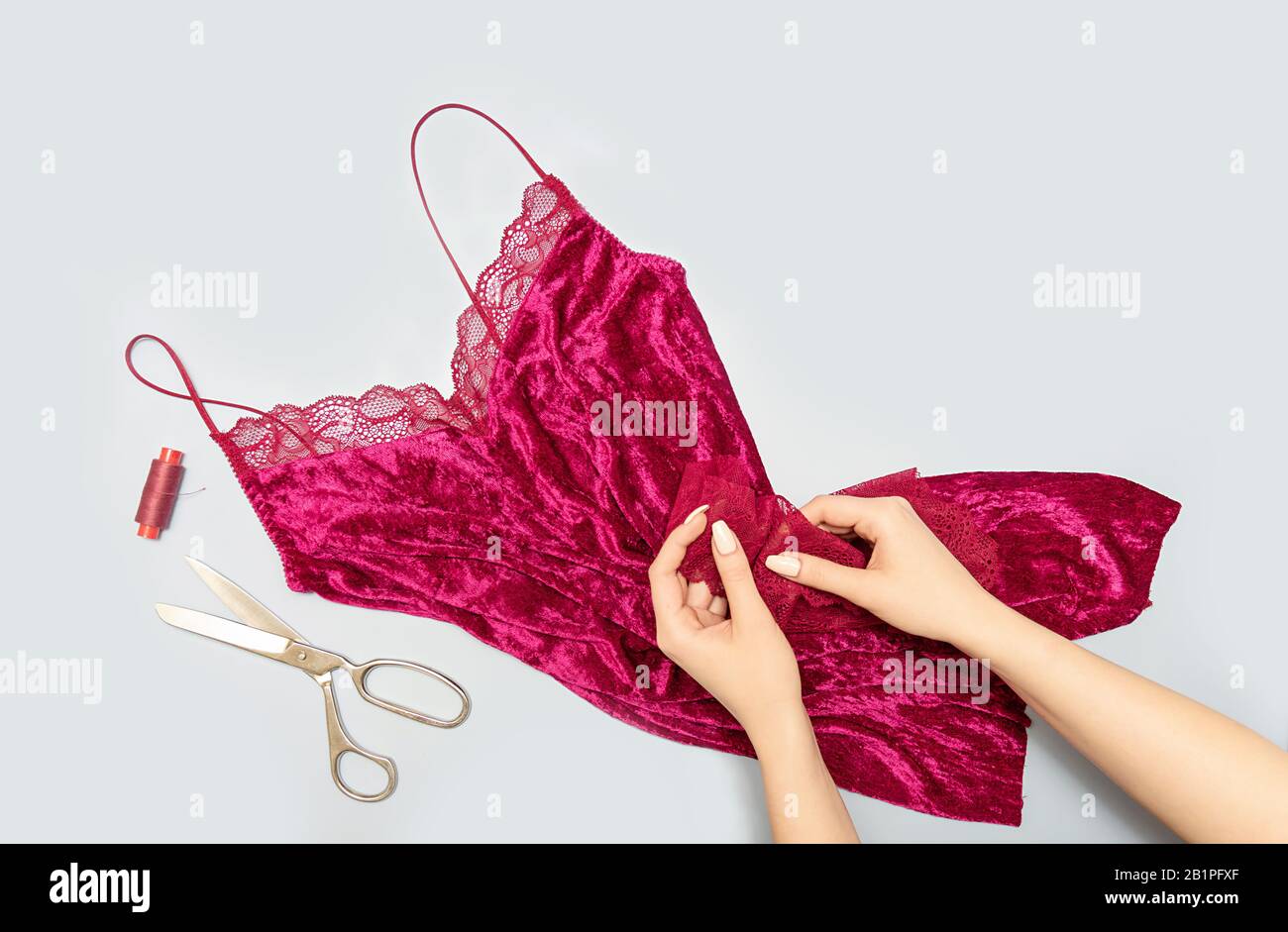 The process of manually sewing linen. Scissors, accessories for sewing. Lace in the hands of a tailor close-up. The apartment was lying. Copy space Stock Photo