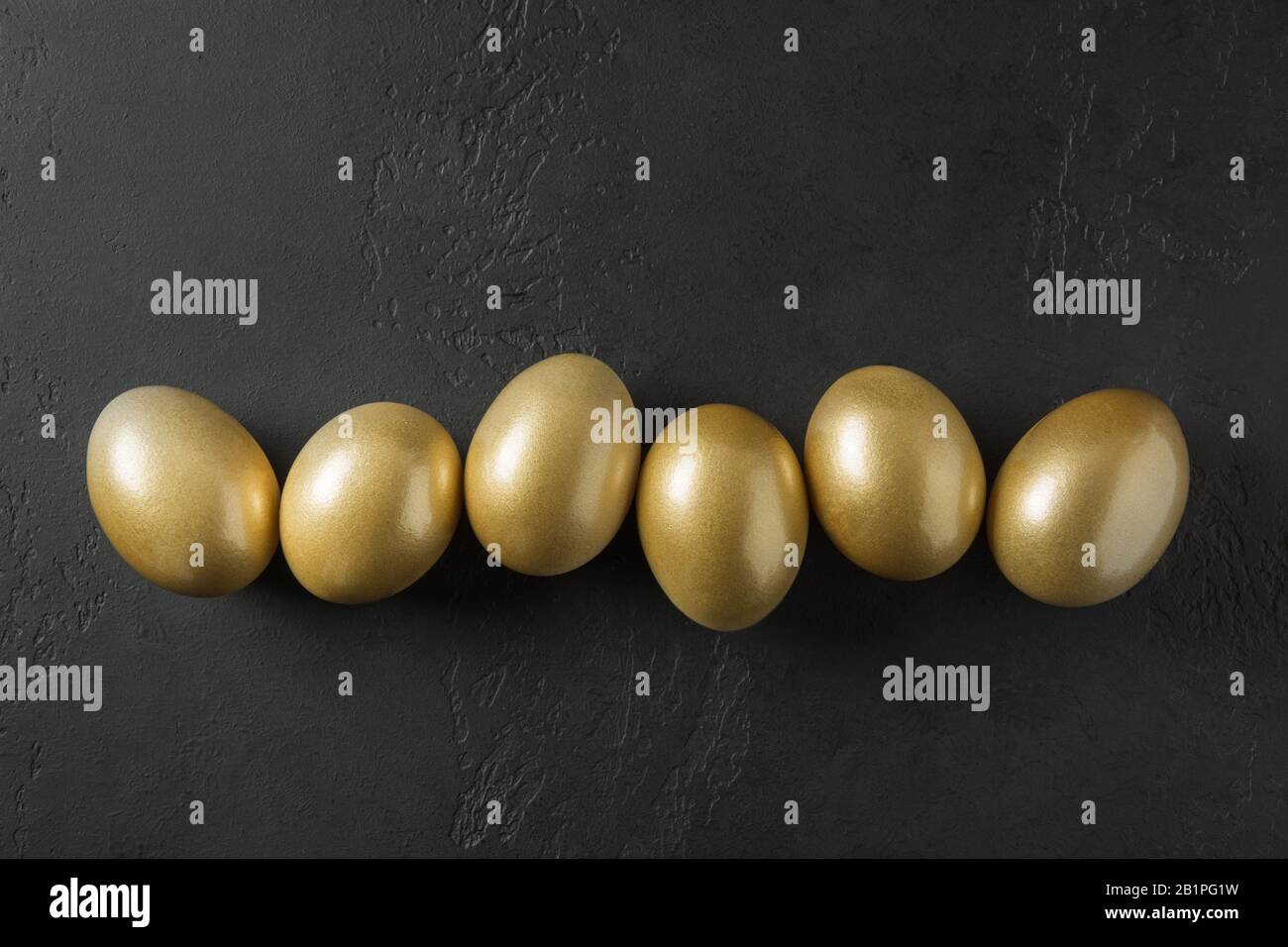 Chicken colored golden eggs on black. Easter dark concept. View from above. Easter composition. Spring. Stock Photo
