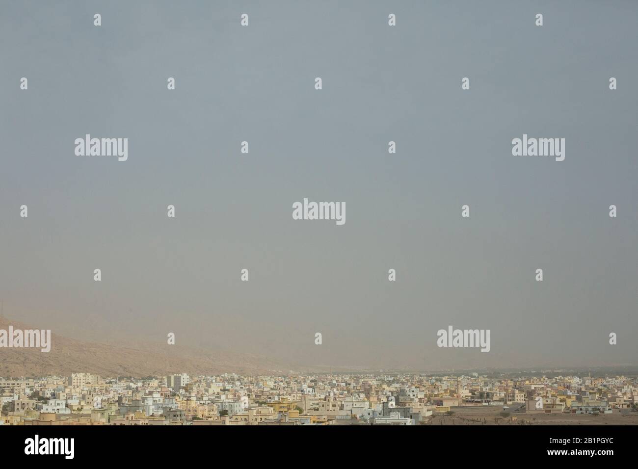 Midday view of the houses in Muscat and surrounding mountains in Muscat, the capital of the Sultanate of Oman. Stock Photo