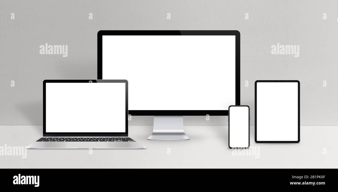 Responsive design devices mockup. Laptop, computer display, phone and tablet with isolated screen on work desk Stock Photo