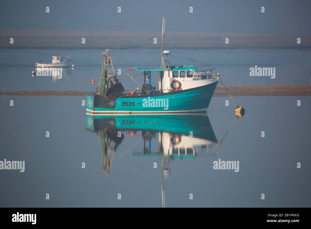 fishing boats at anchor in the morning mist on the estuary Stock Photo