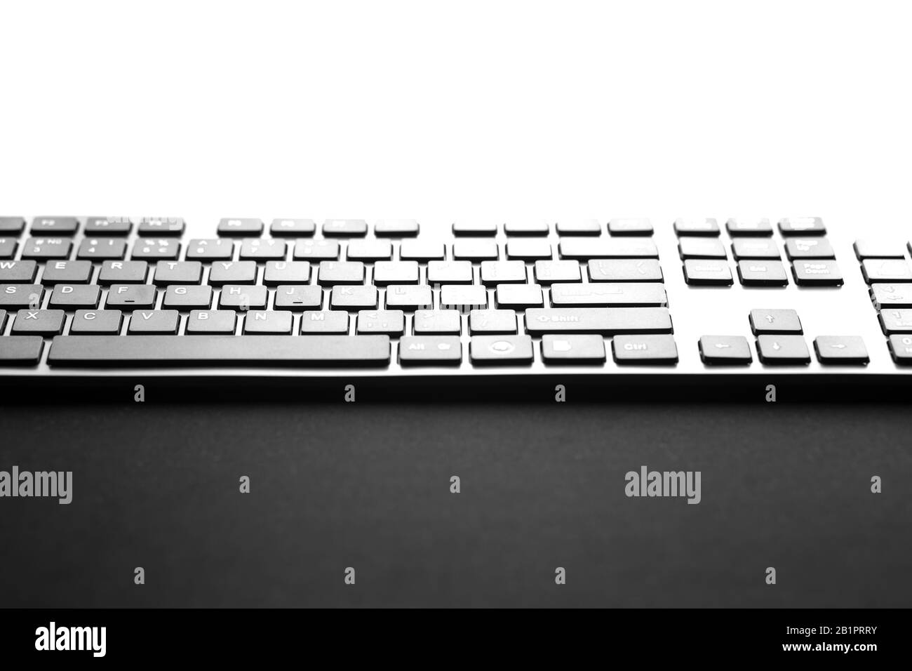 Keyboard with copy space up adn down. Black keyboard in a front of monitor. Stock Photo