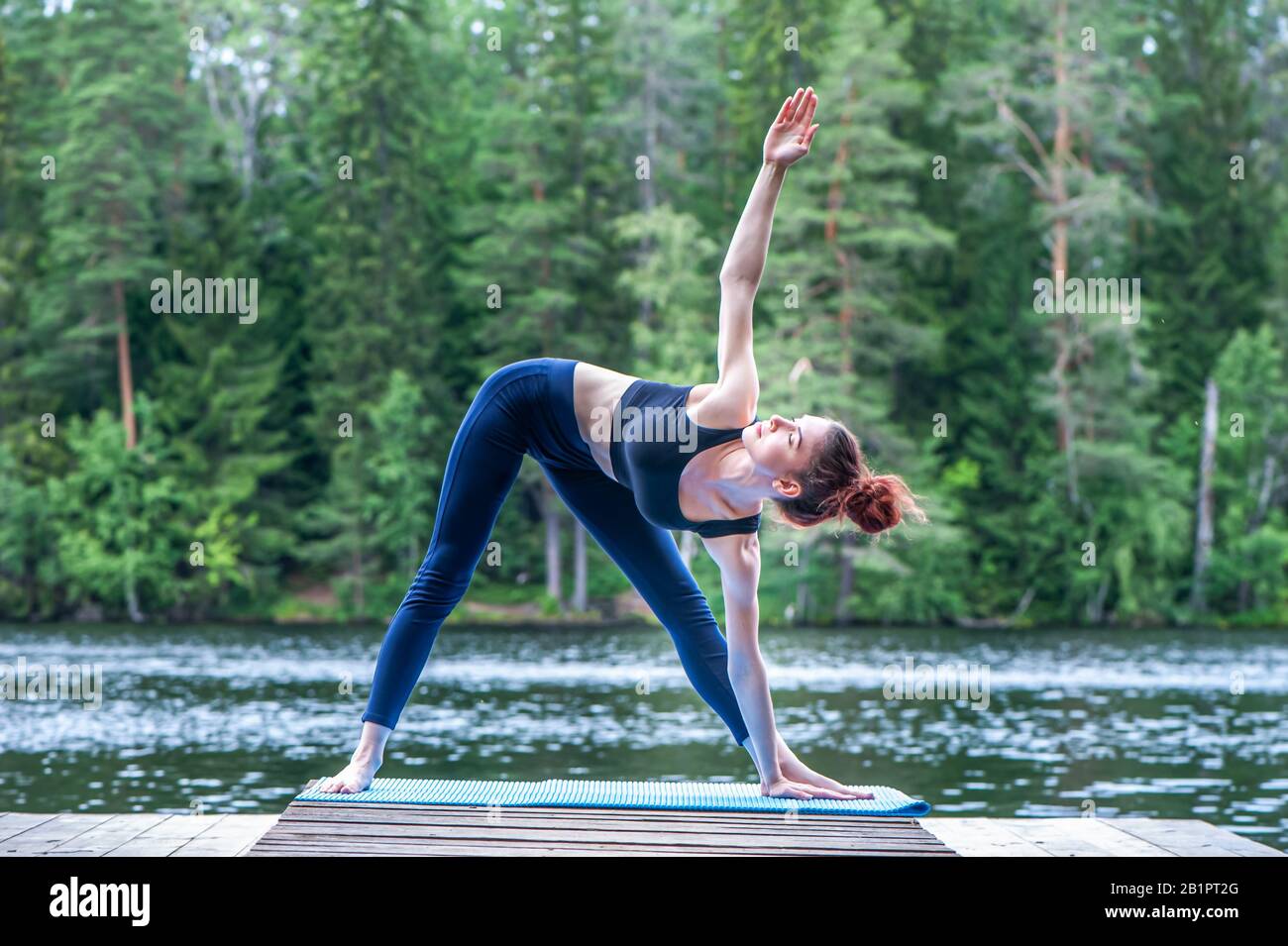 Yogi girl practicing yoga, doing Utthita Trikonasana exercise, extended ...