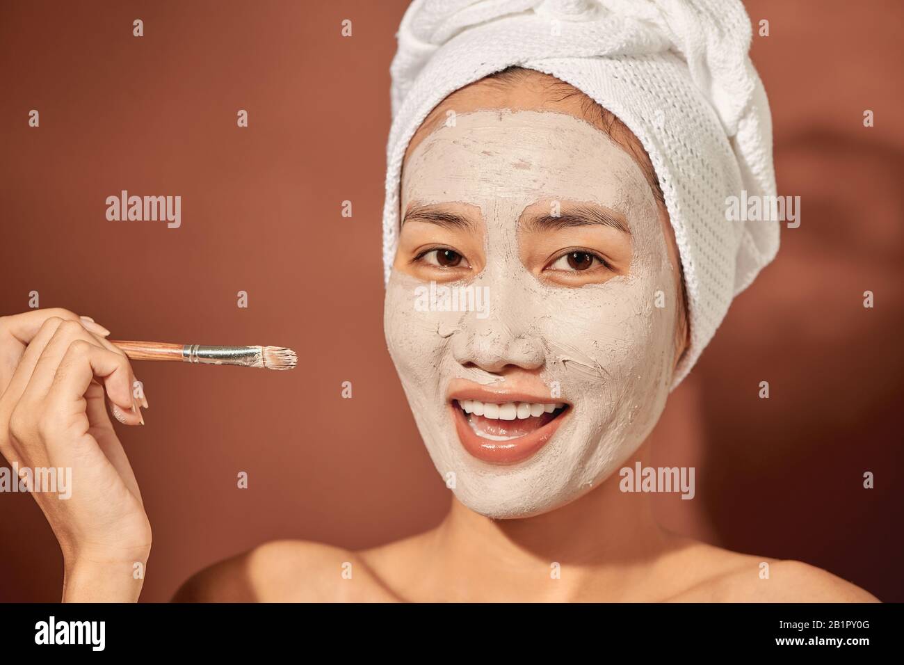 Spa Woman applying Facial clay Mask. Beauty Treatments. Stock Photo