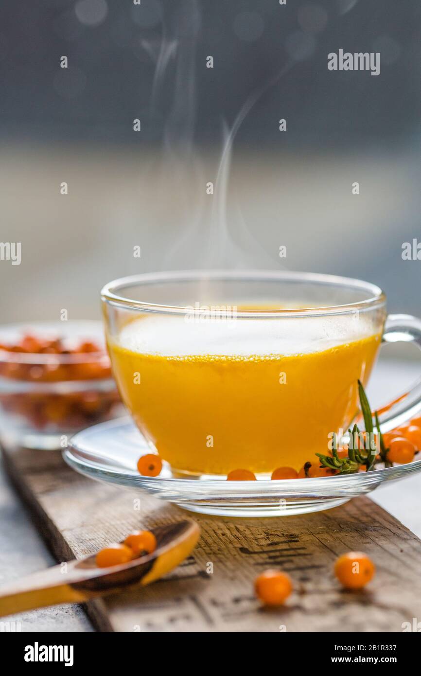 Sea buckthorn tea  in a glass cup before window.   Herbal vitamin beverage Stock Photo
