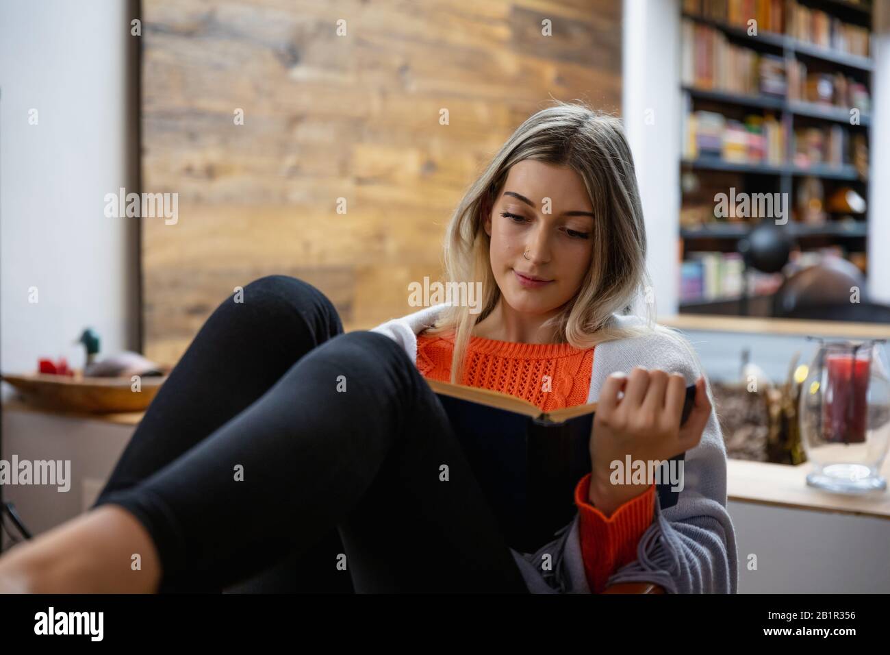 Young woman reading a book home Stock Photo