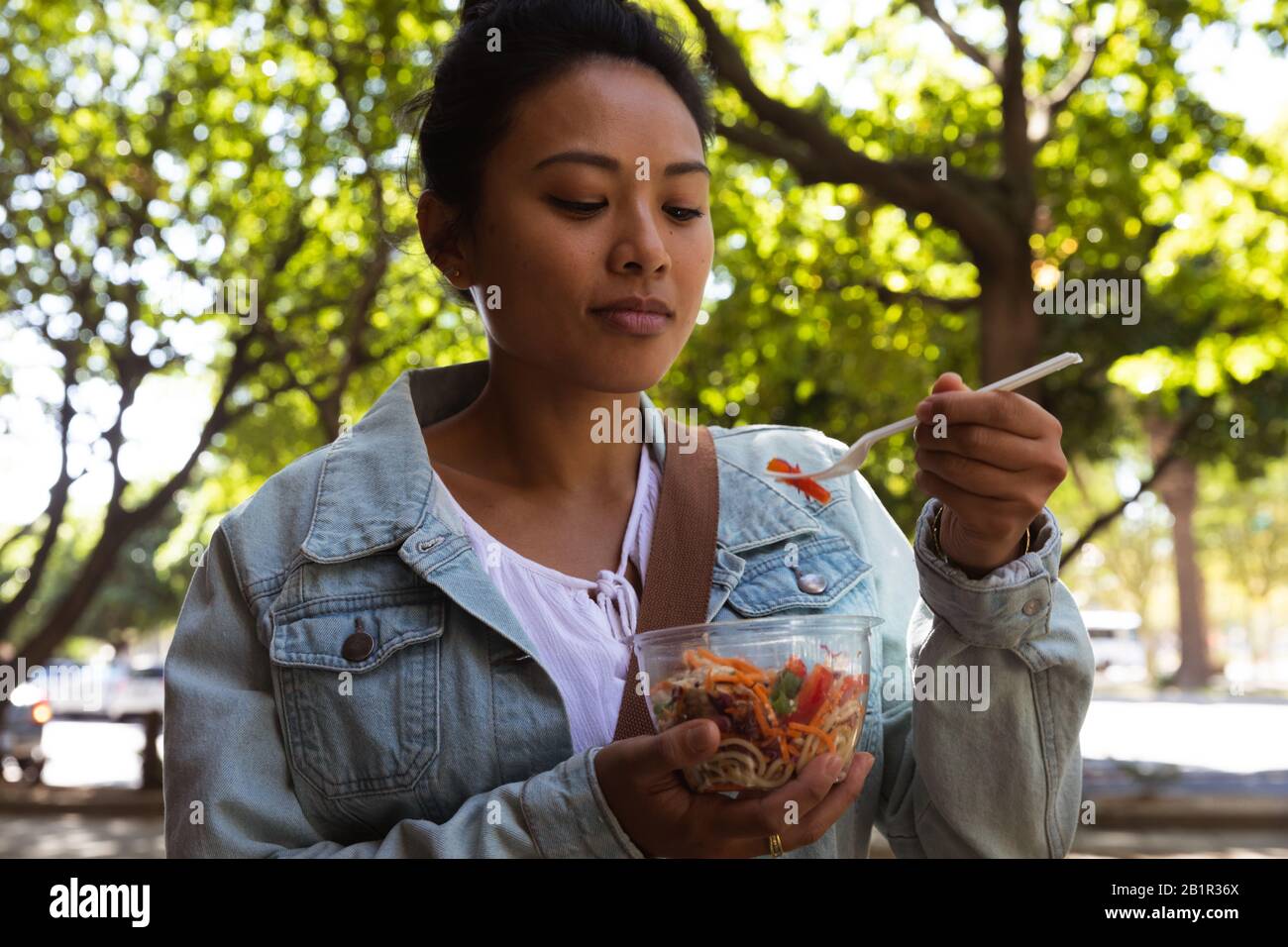 Woman eating on the street Stock Photo