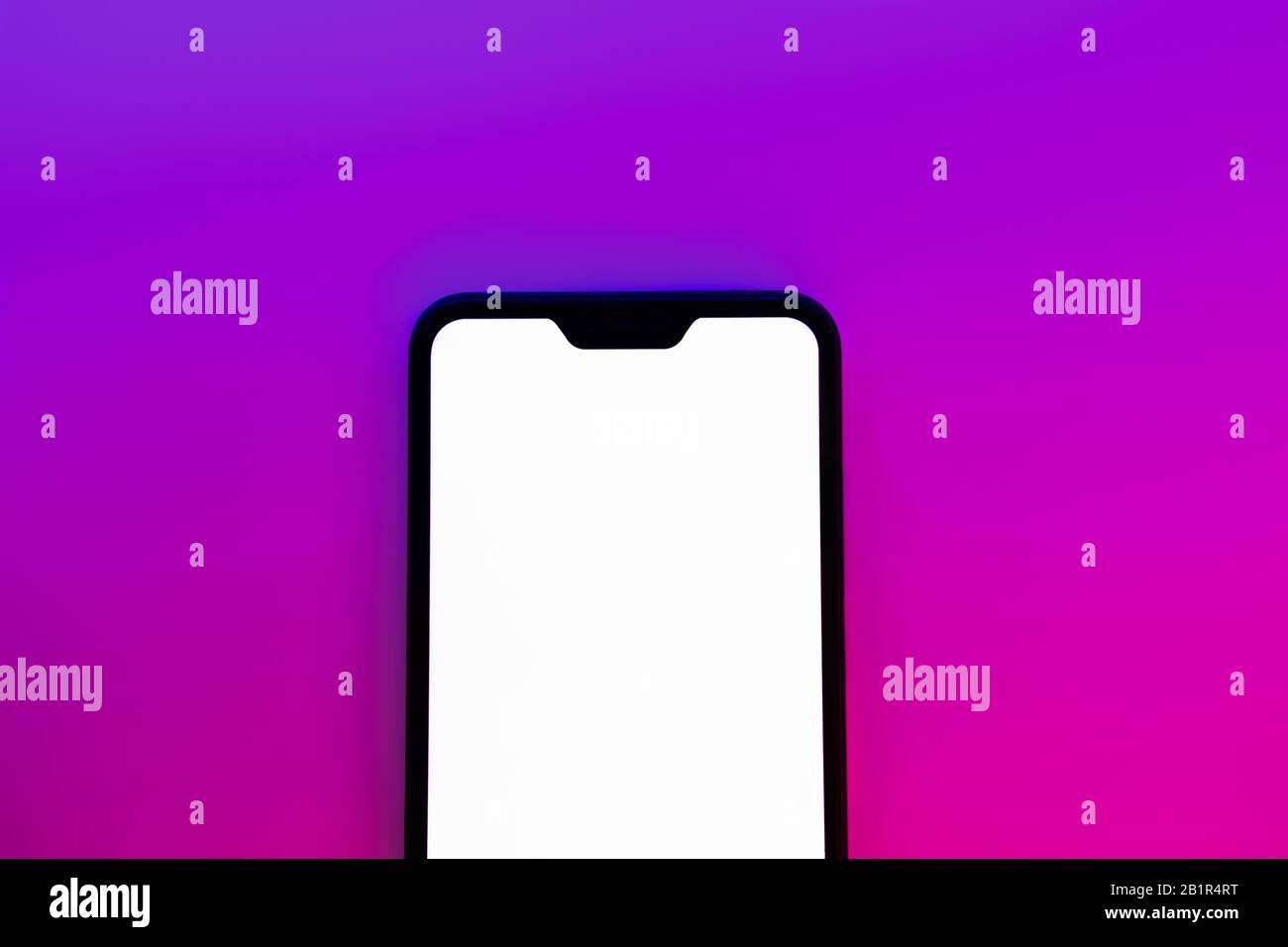 Modern generic smartphone in neon backdrop. Cellphone with white screen in vibrant blue and red background Stock Photo