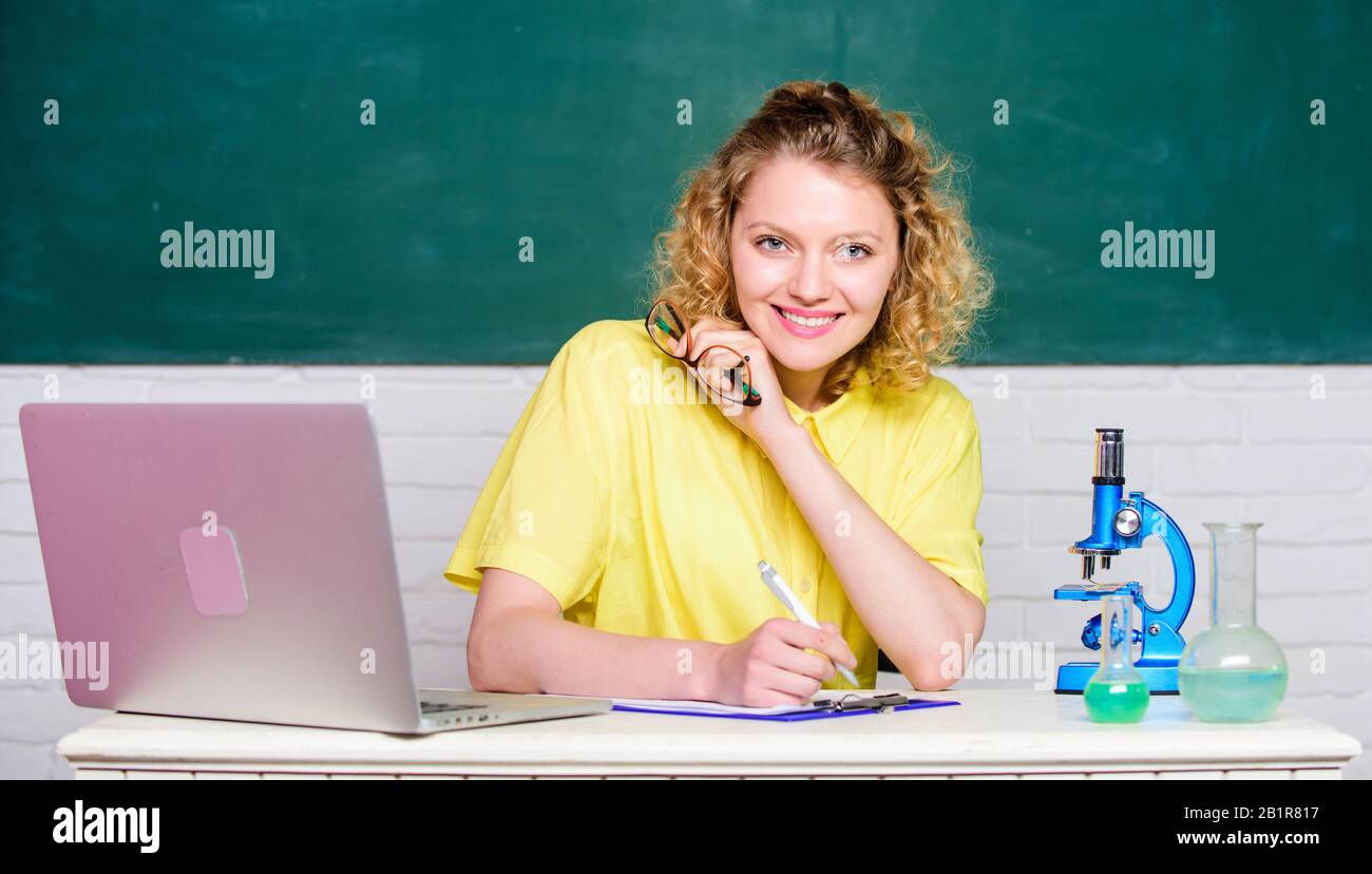 Chemical industry. girl in classroom laboratory. happy student with microscope and beaker. biology experiment research. make notes about chemistry research results. scientist at school lab. Stock Photo