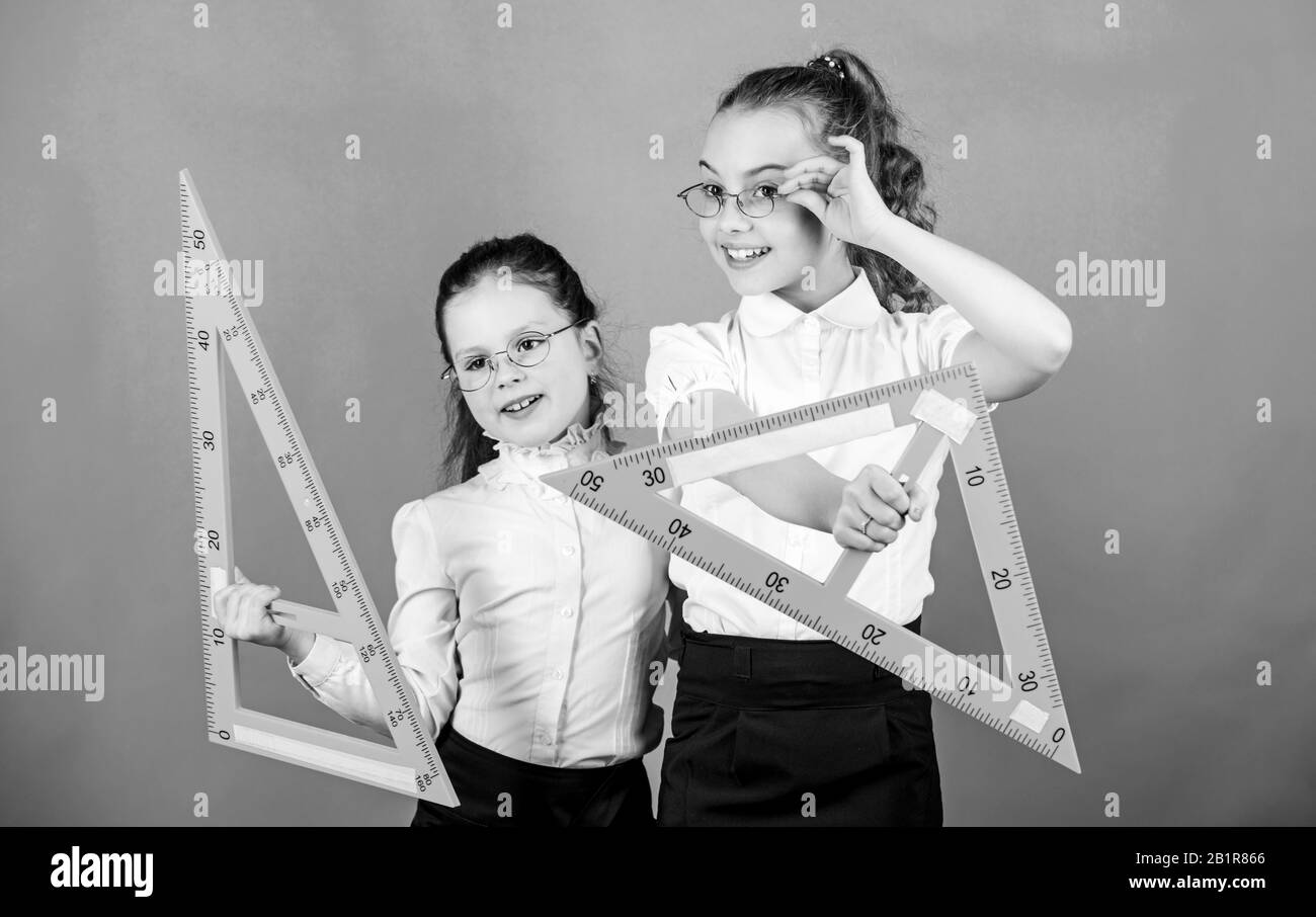 School students learning geometry. Pupil cute girls with big rulers ...