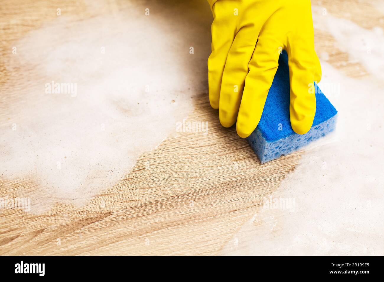 Employee using sponge for cleaning wood table Stock Photo Alamy