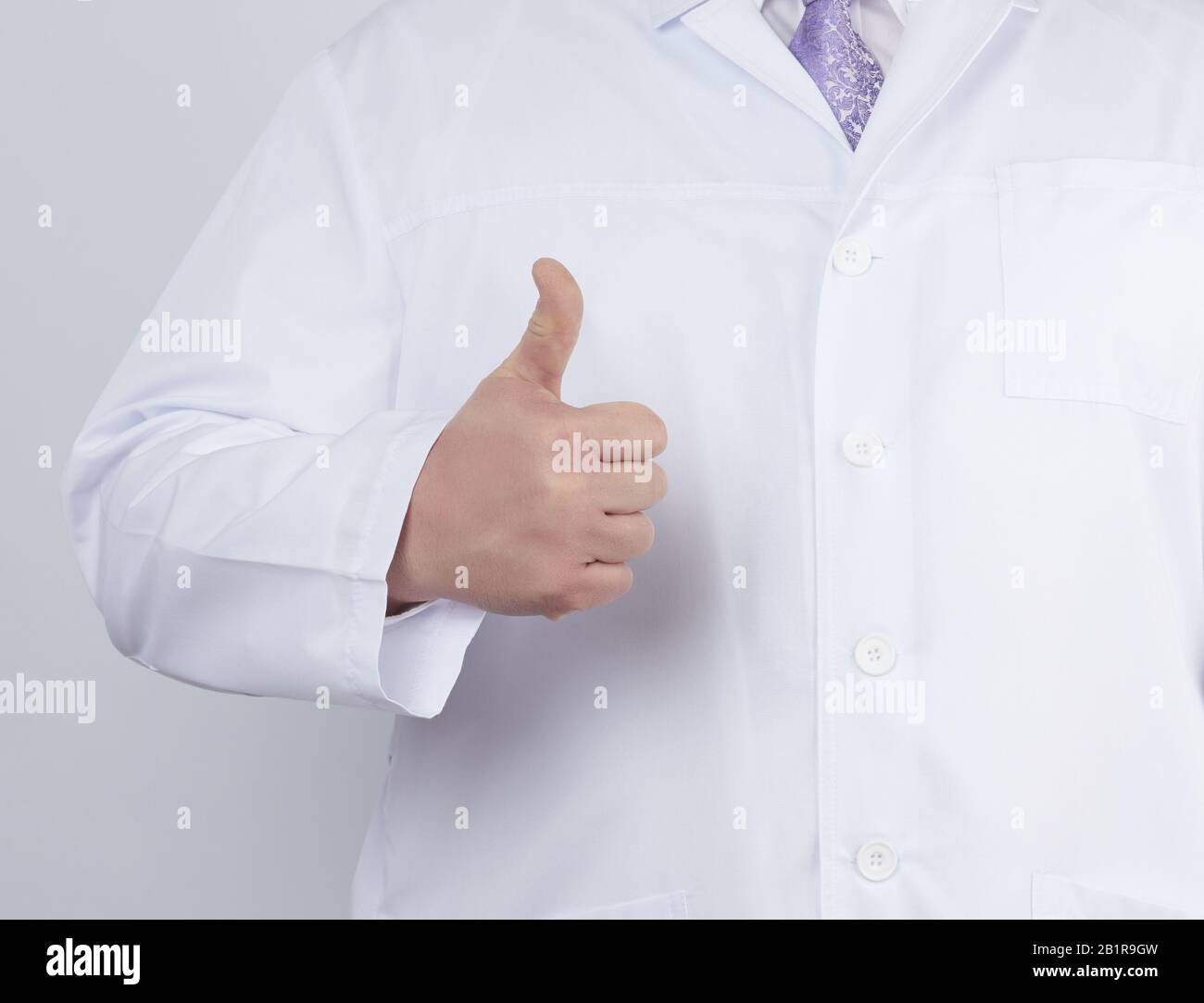 doctor in a white coat and tie shows with his hand a gesture like