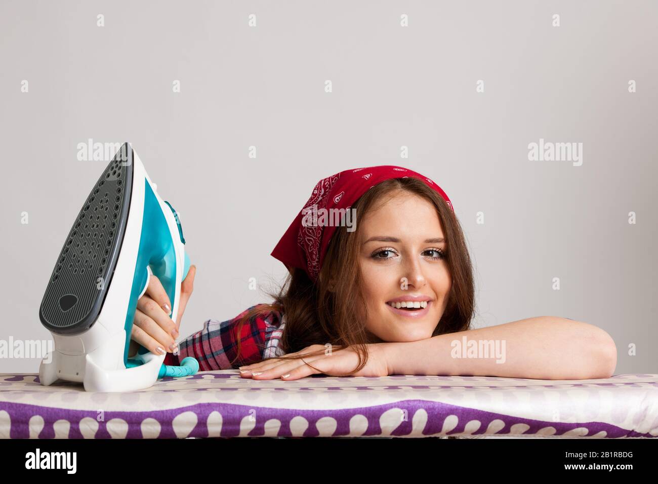 Happy woman ironing loundry isolated over white background Stock Photo