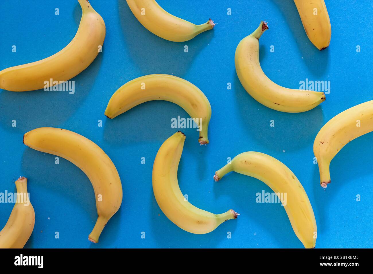 Colorful pattern with fresh bananas on blue background. Wallpaper Stock Photo