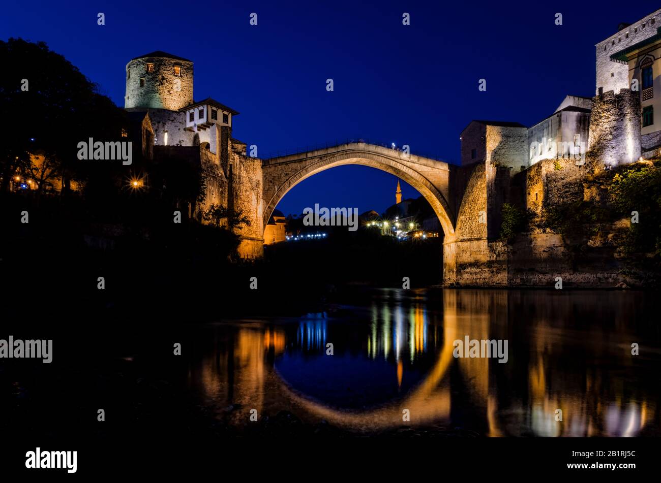 The old Bridge of Mostar (Stari Miost) and its reflection in the water of the Neretva River, at blue hour Stock Photo