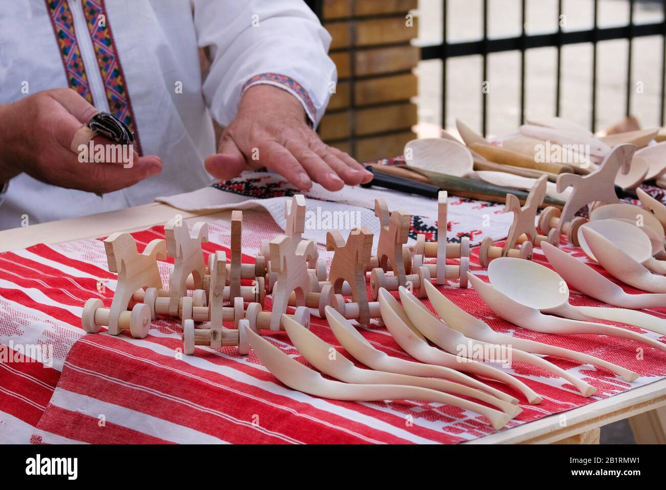 Craftsman put up for sale wooden hand-made toys and spoons. National crafts concept. Stock Photo