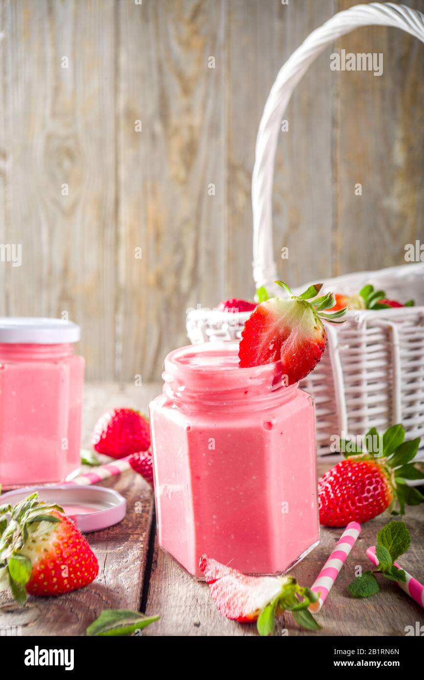 Strawberry milkshake in bottles, with fresh strawberries and mint on