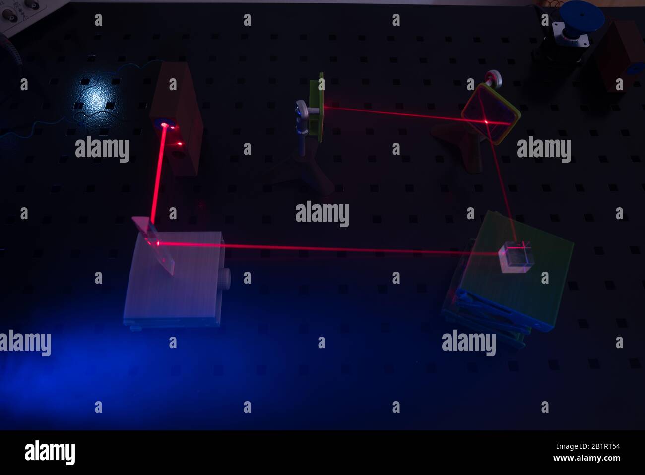 Experiment in optic lab with laser device. Red laser on optical table