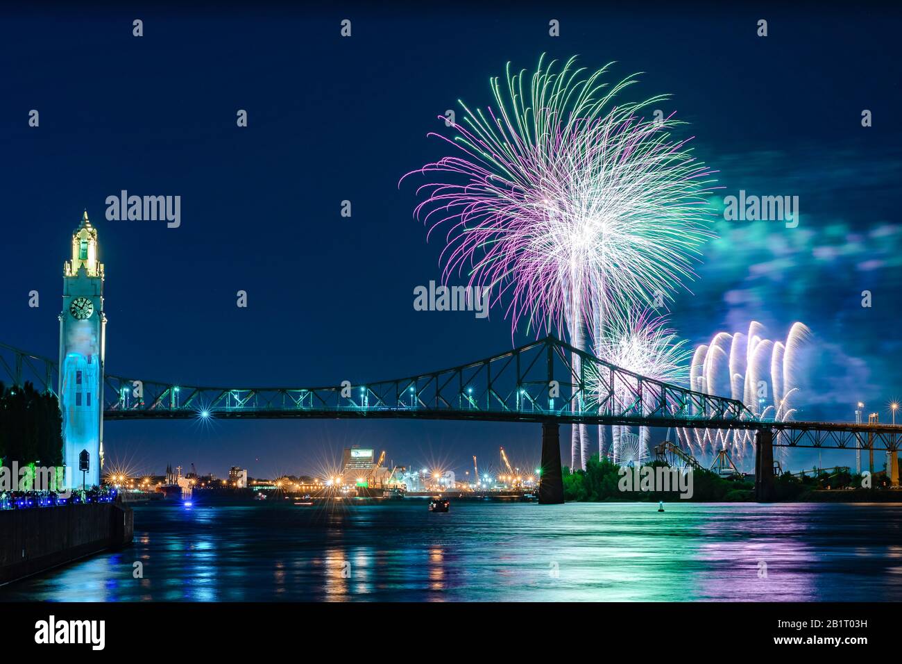 City fireworks against blue sky over a bridge Stock Photo
