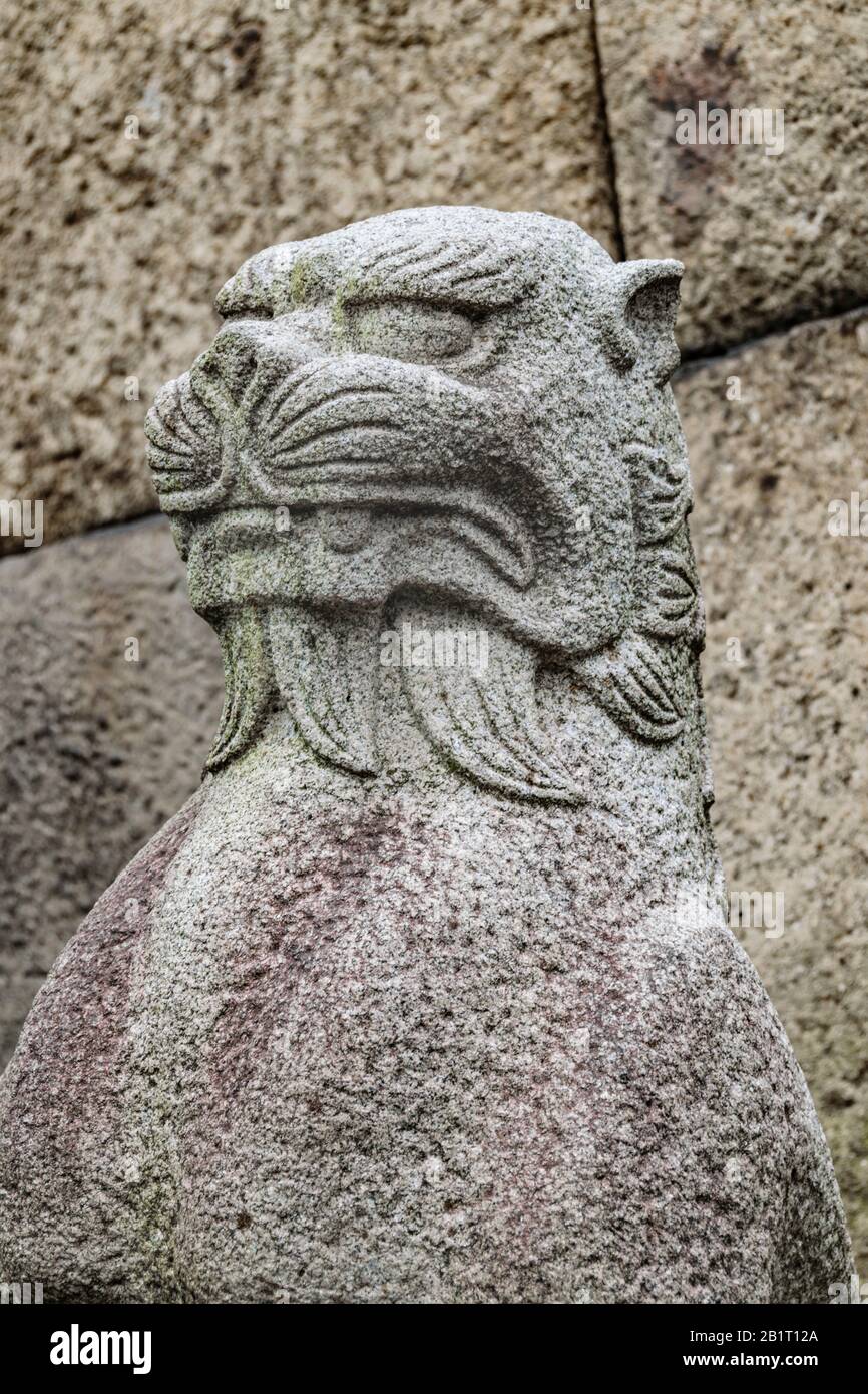 Japanese mythological feline stone sculpture over stone wall background Stock Photo Alamy