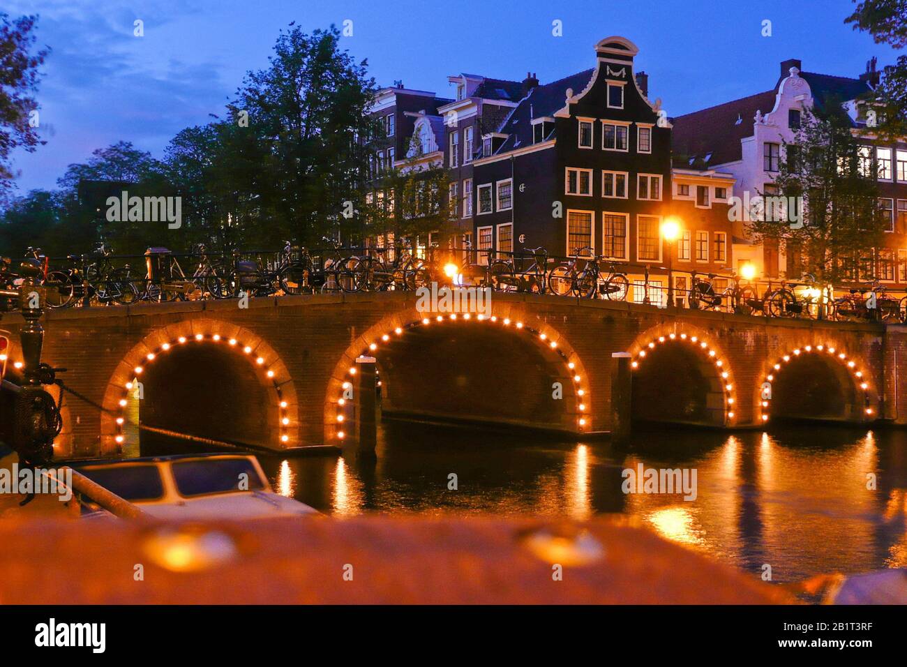 Amsterdam in den Niederlanden, beleuchtete Bruecke bei Nacht, Grachten, Stock Photo