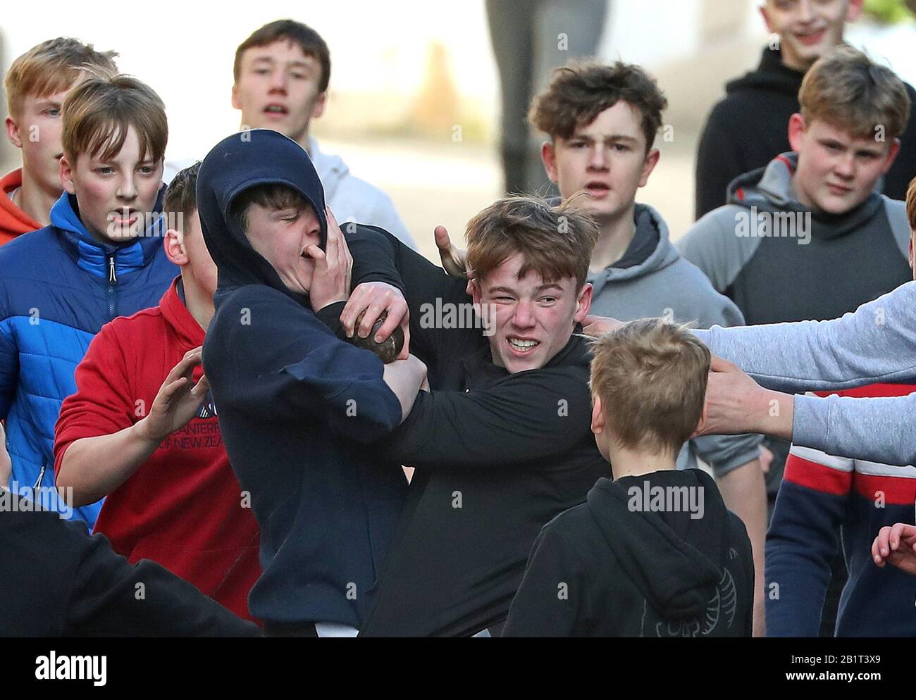 Boys tussle for the leather ball during the annual Jedburgh ba' game event on Jedburgh's High Street in the Scottish Borders. Picture date: Thursday February 27, 2020. The annual event started in the 1700s and the first ever game was supposedly played with an Englishman's head. It involves two teams, the Uppies (residents from the higher part of Jedburgh) and the Doonies (residents from the lower part of Jedburgh) getting the ball to either the top or bottom of the town. The ball, which is made of leather, stuffed with straw and decorated with ribbons representing hair, is thrown into the crow Stock Photo