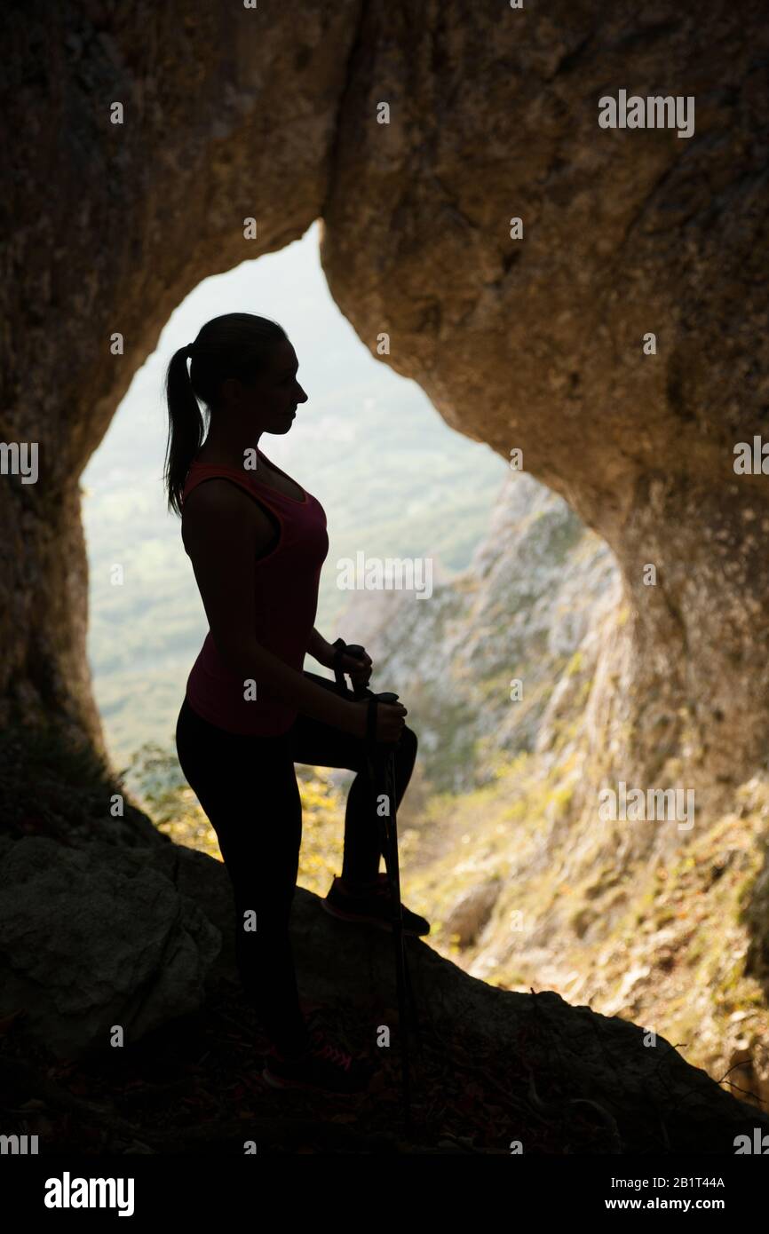 Silhouette of a beautiful young woman hiking the mountains Stock Photo