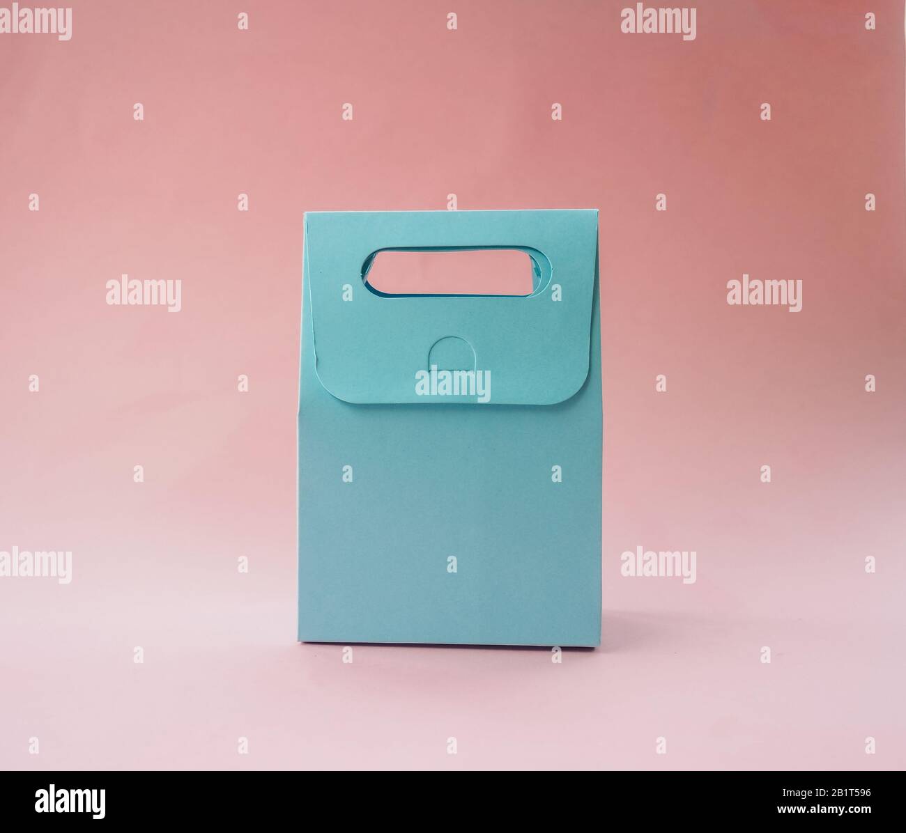 paper blue gift bag on pink background. Stock Photo