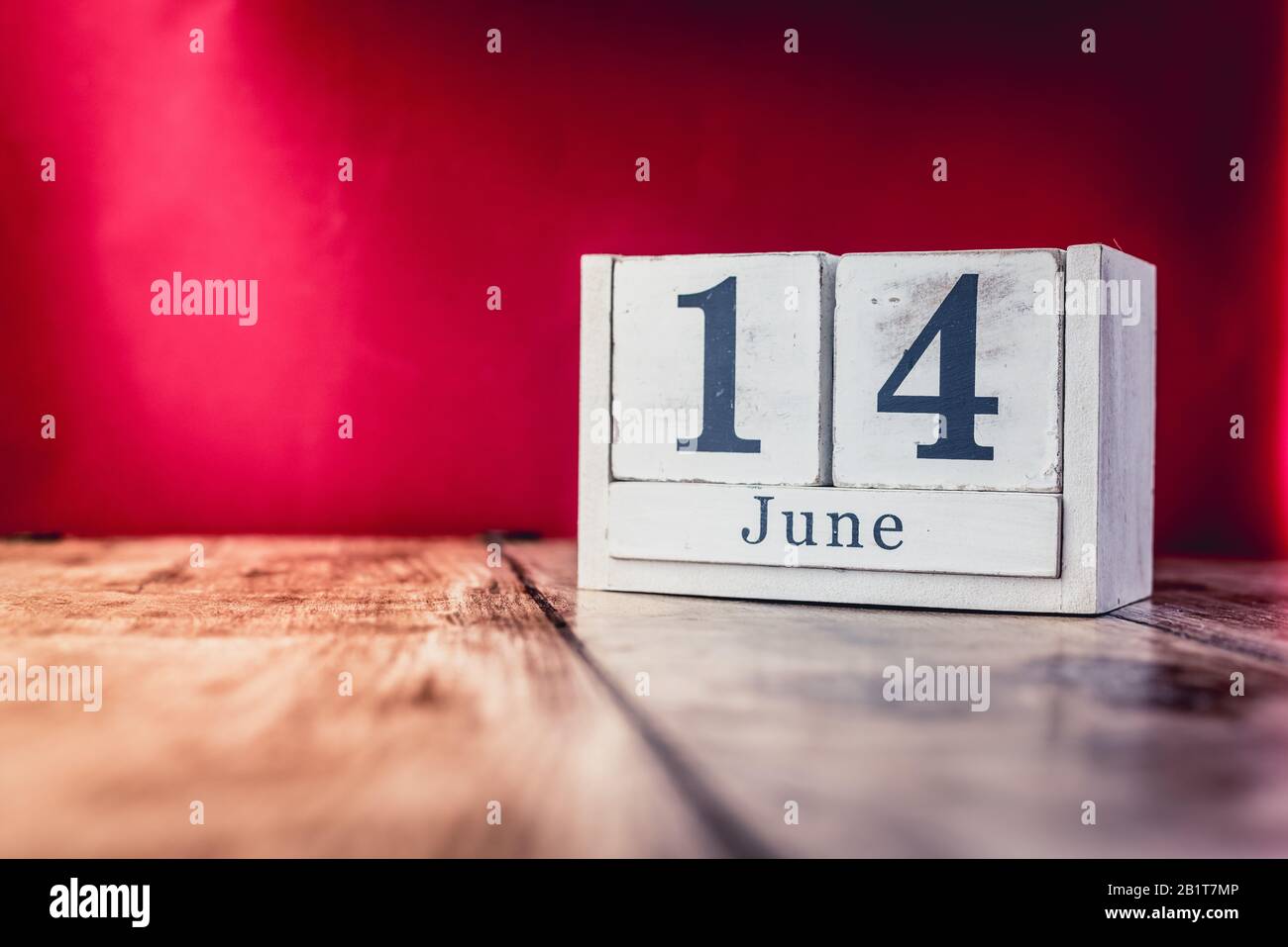 June 14th. Day 14 of month, calendar on business office table, workplace with vivid maroon red background. Summer time Stock Photo