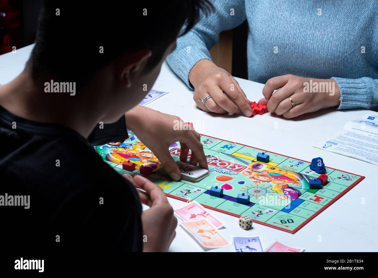 Teenagers playing monopoly board game together Stock Photo