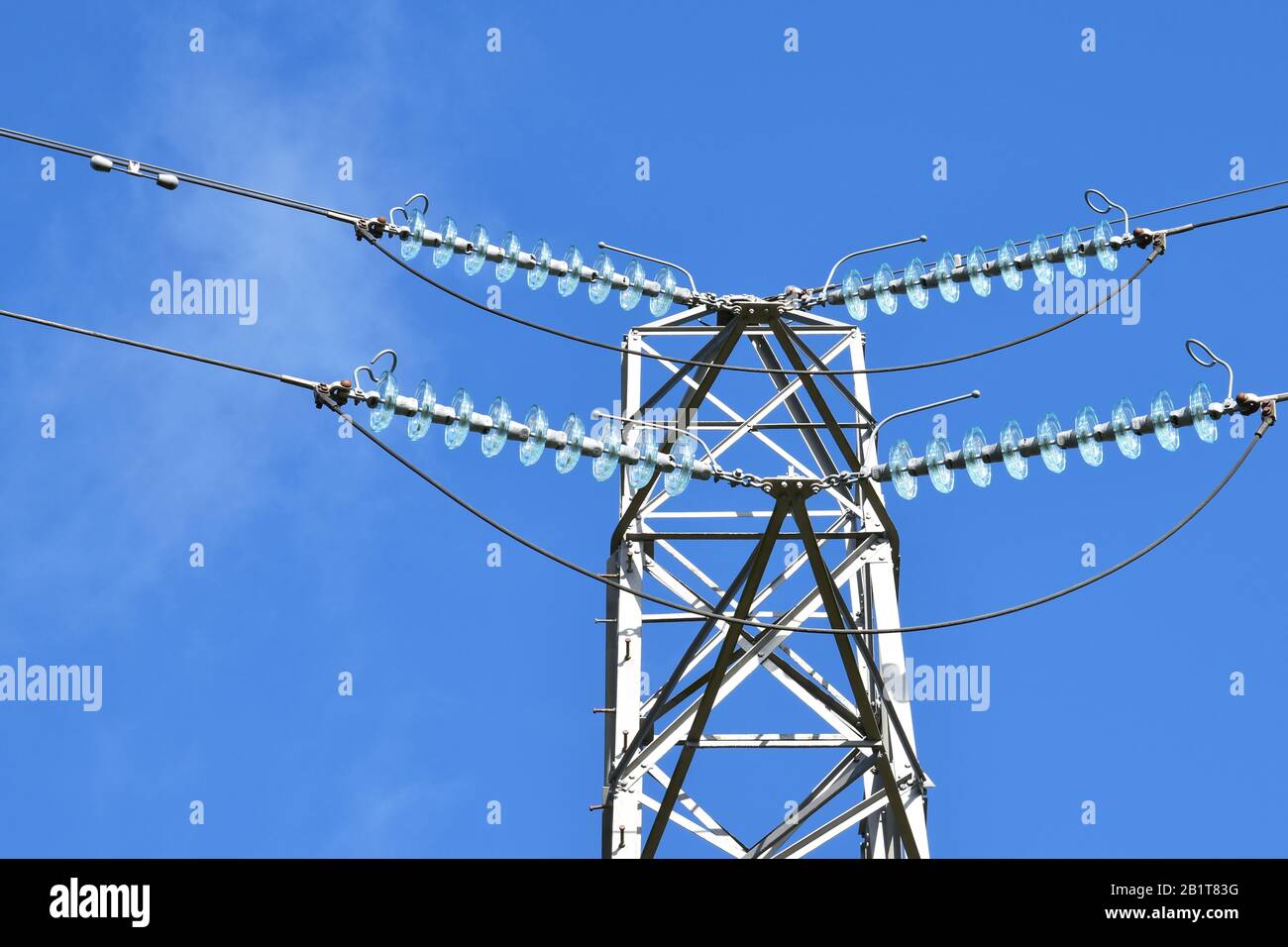Isolated top of electricity pylon showing insulating cables, bypass ...