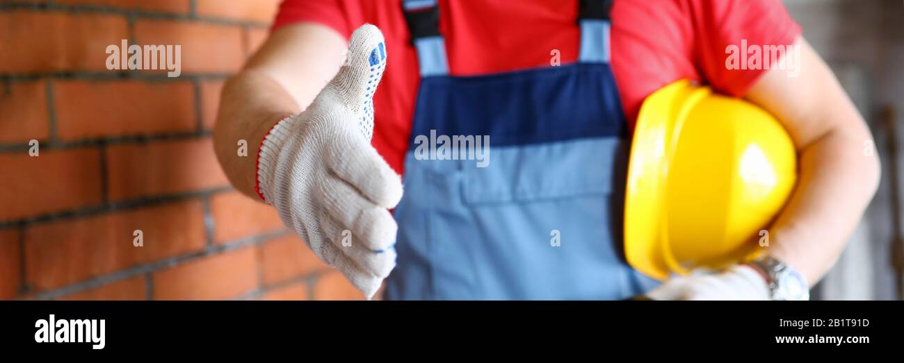 Worker at construction site offering hand to shake Stock Photo