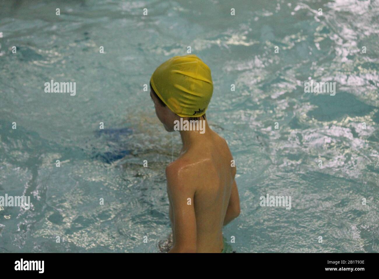 little schoolboy in crystal blue water on swimming  pool on the lesson of physical training Stock Photo