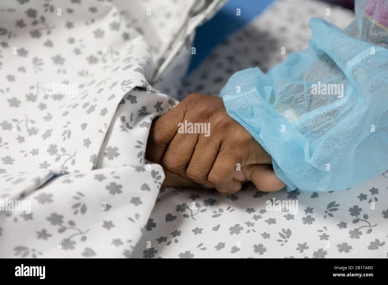 close up of a mother holding her son's feet who is recovering in a children's hospital Stock Photo