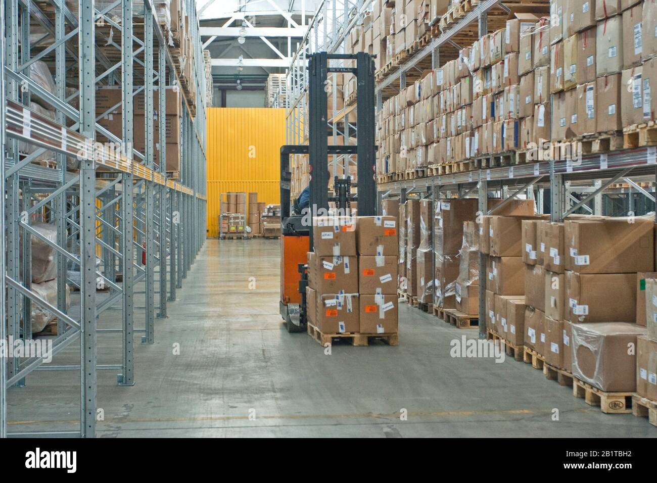 large modern empty warehouse, industrial interior with forklifts. shelves with pallets, boxes, containers and goods Stock Photo