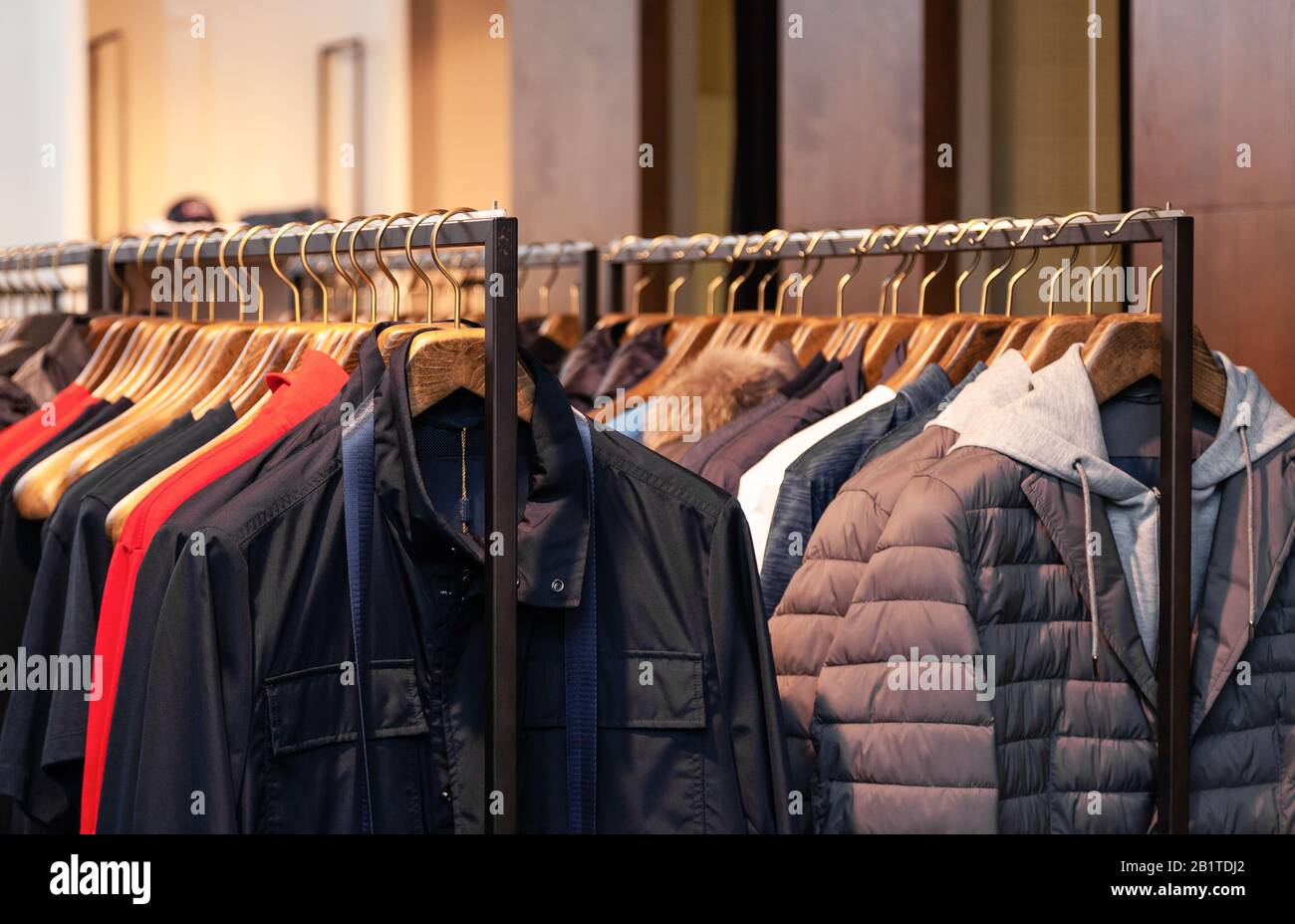 Closeup colorful male, female clothes in boutique hanging on hangers, clothing rack on metal stand. Concept opening luxury shop, shopping mall, store Stock Photo