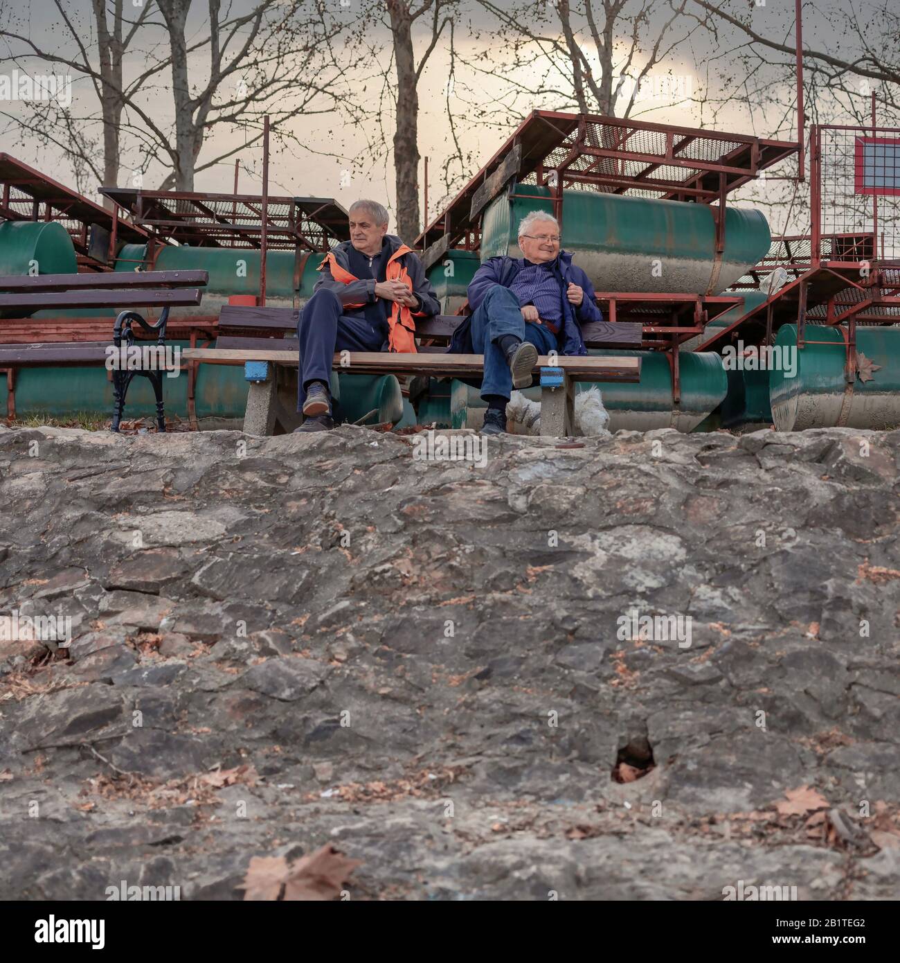 Serbia, Feb 25, 2020: Old friends sitting on a bench at Danube River embankment in Sremski Karlovci Stock Photo
