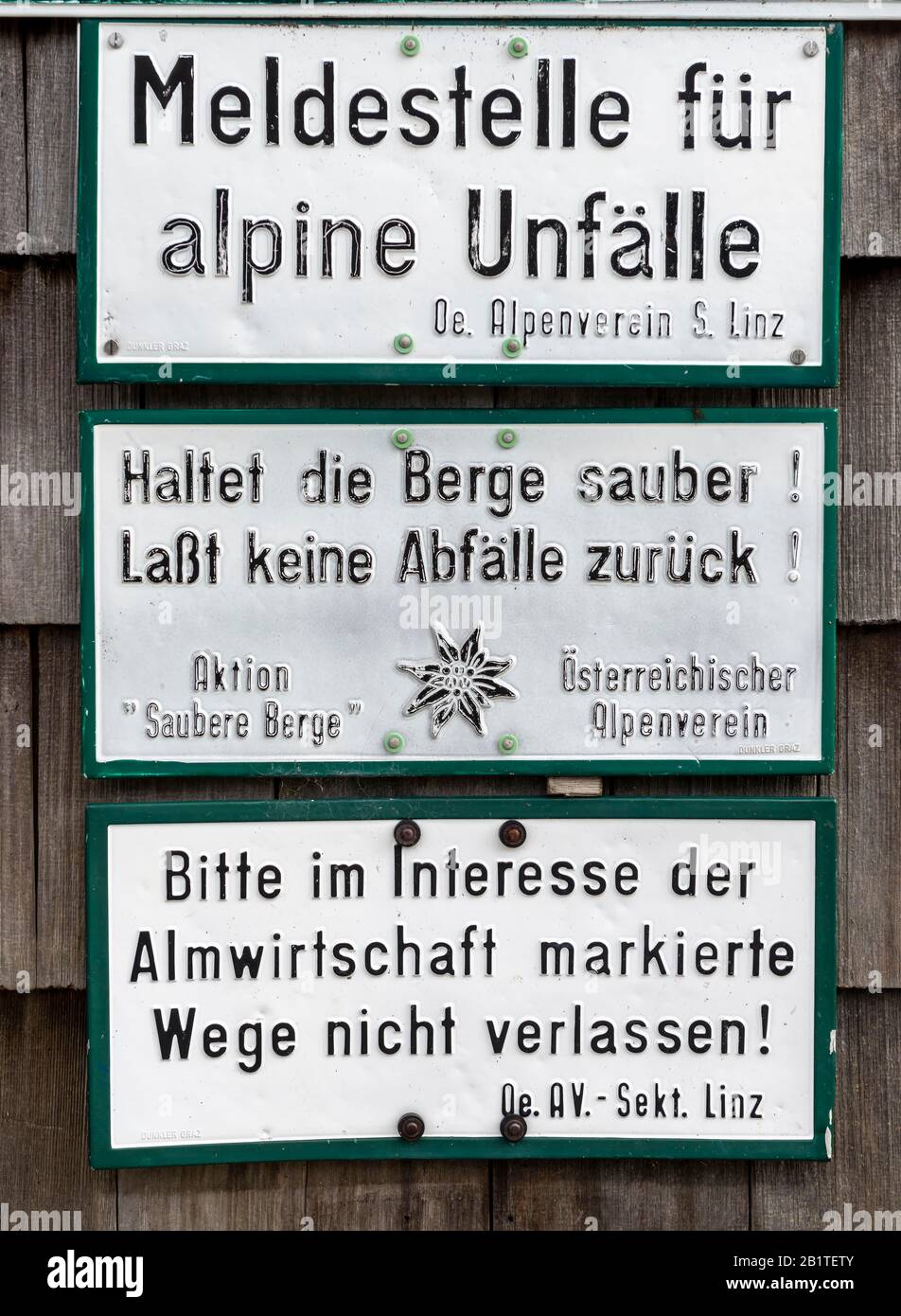 Reporting point for alpine accidents, Keep the mountains clean, Do not leave any waste behind, Do not leave marked paths, Signs at a hut, Alpenverein Stock Photo