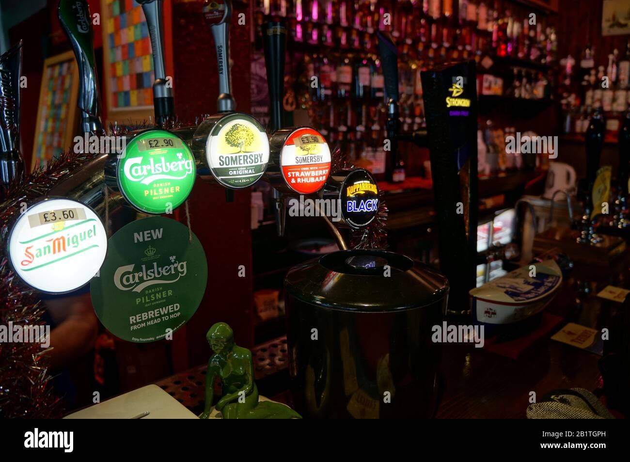 Beer brands displayed on the beer pumps behind the pub bar Stock Photo