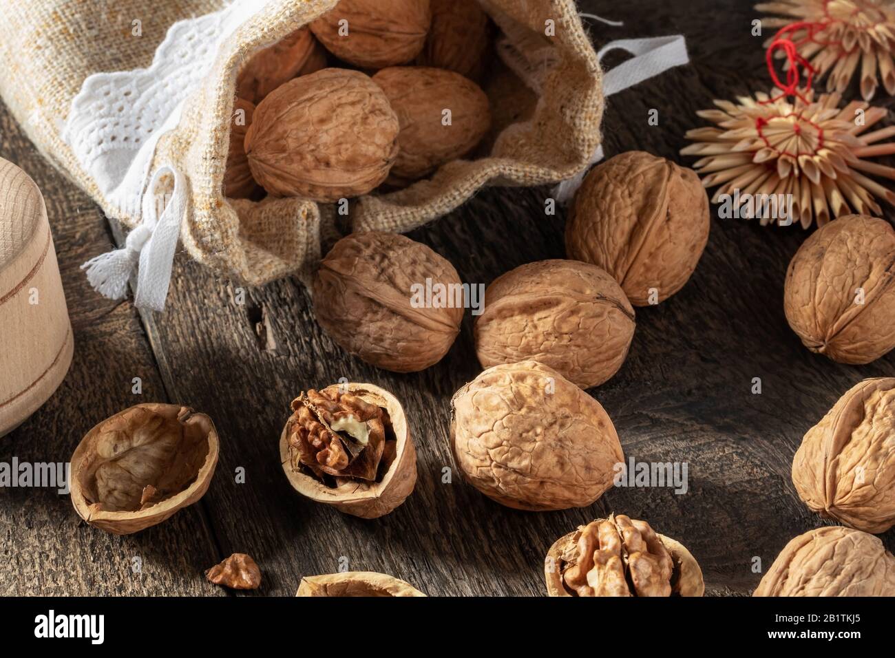 Walnuts spilled from a linen bag on a table Stock Photo