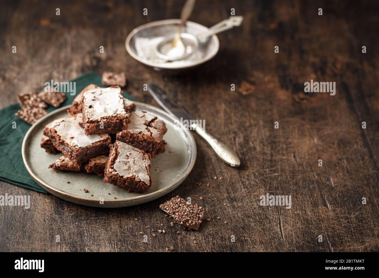 Slices Homemade brownie cakes with dark chocolate sprinkled with icing sugar on a dark background. Place for text Stock Photo