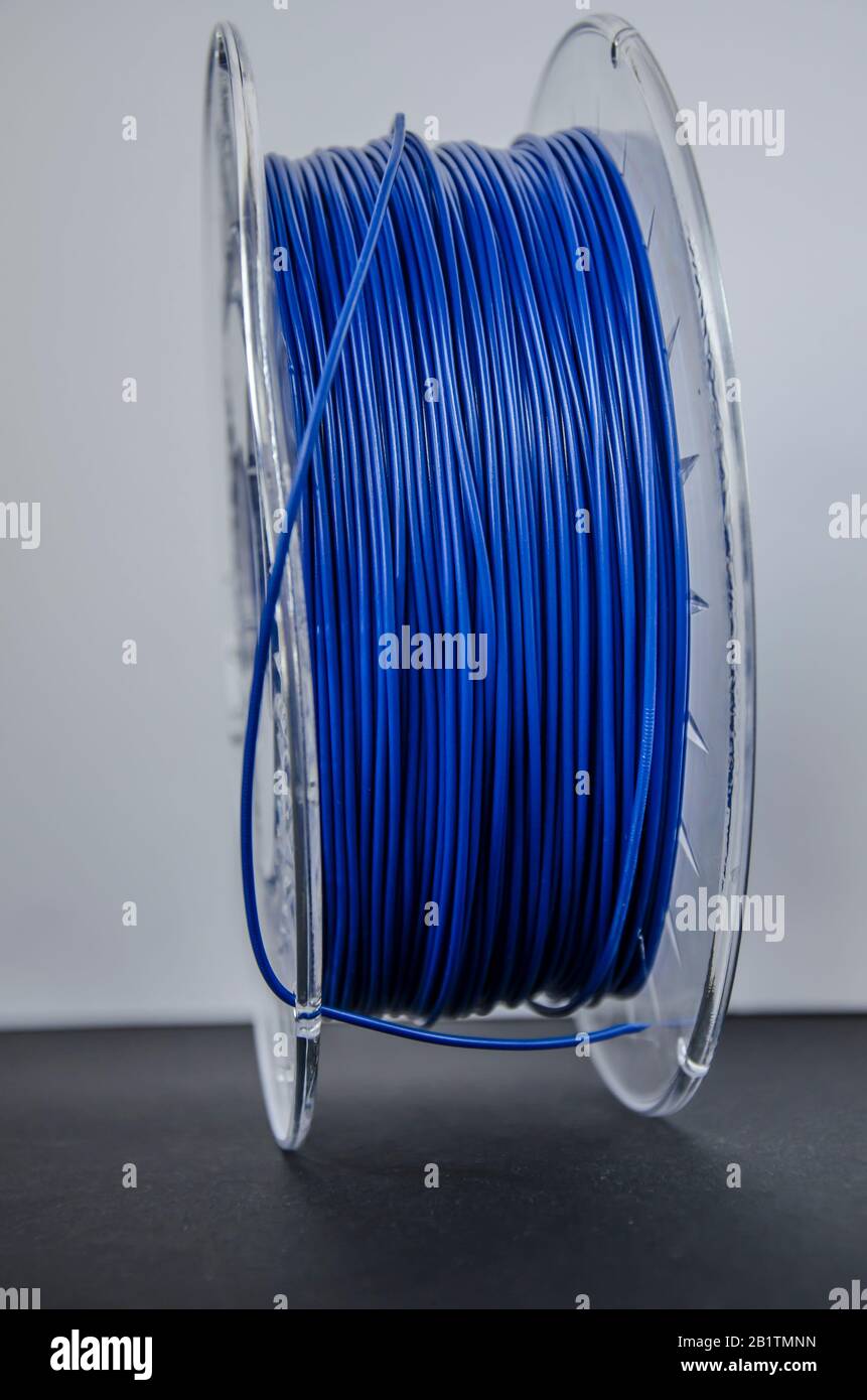 Plastic for 3D printing. Blue plastic filament, red ABS/PLA coil for 3d printer on white background, isolated Stock Photo